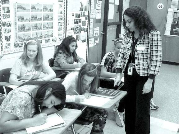 Macopin School employee Abby Beyjoun, special education aide, takes time to share her experiences as a clothing designer and seamstress with Macopin School 8th graders at Career Day 2013.