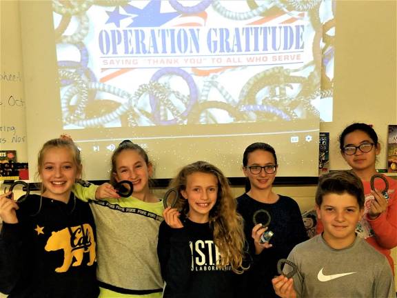 Submitted photo Maple Road Elementary School's Youth Act Club of sixth graders make bracelets for soldiers overseas in October.