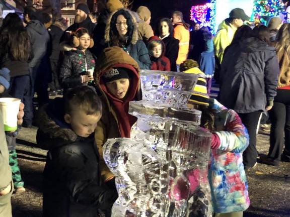 Children examine a snowman carved from a 300-pound block of ice. Jimmy Chiappa of Jimmy’s Artistic Creations in Rutherford said he did the carving in 22 minutes. (Photo by Kathy Shwiff)