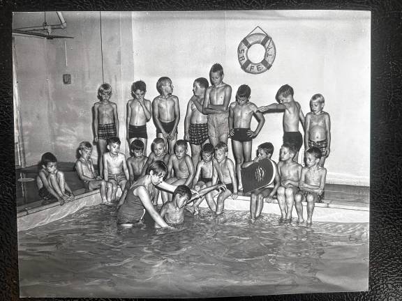 PL1 Boys watch and wait their turn while a classmate gets a swim lesson at a pool in the basement of the Idylease building. (File photos by Ann Genader)