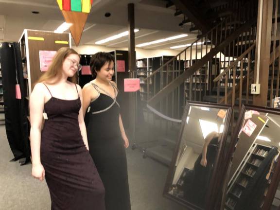 Senior Daphne King, left, and junior Sara Melendez try on dresses at the Cinderella Project dress sale, organized by the West Milford High School Interact Club. (Photos by Kathy Shwiff)