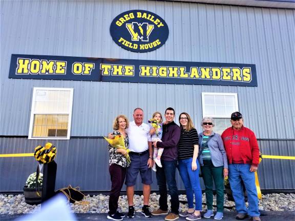 Greg Bailey and his family stand in front of the new field house bearing his name at McCormack Field during a Sept. 27 ceremony.