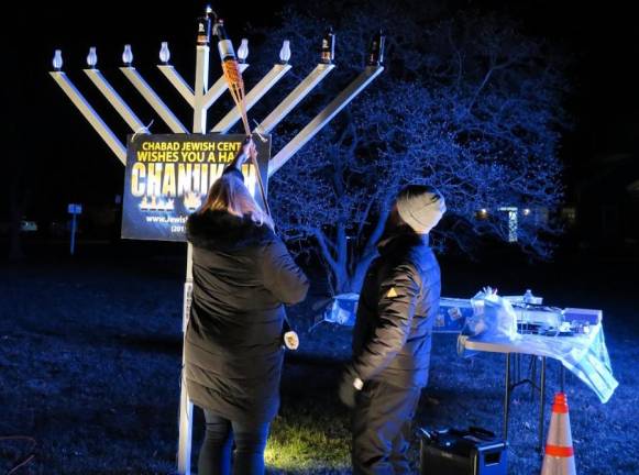 Rabbi Gurkov led the group of gatherers in traditional prayers and melodic blessings, and then invited West Milford Mayor Michele Dale to light the shamash - the center “attendant” flame (or ninth candle of the menorah) from which all of the eight flames are lit - each signifying one day of the miracle eight days/nights - on the giant menorah.