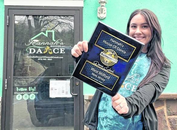 Hannah's House of Dance owner Hannah Porcaro holds a plaque.