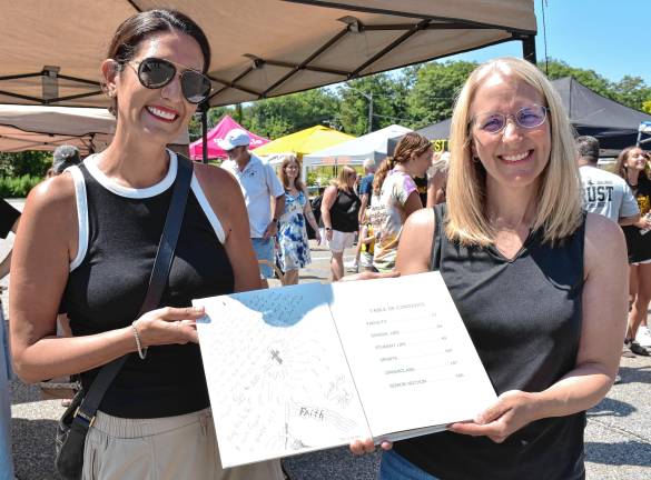 Jodie Chorbajian, left, and Heidi Gessler Cassels hold a West Milford High School yearbook from 1995 with a handwritten message from Jen Pawol. (Photos by Rich Adamonis)