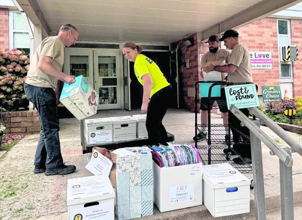 Members of the First Aid Squad pack up donated school supplies.