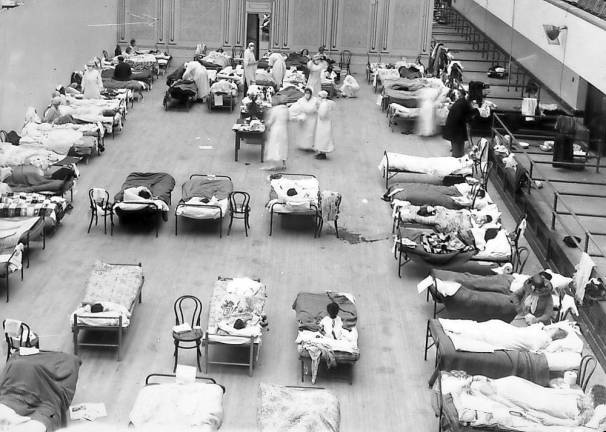 American Red Cross nurses tend to flu patients in temporary wards set up inside Oakland Municipal Auditorium, 1918