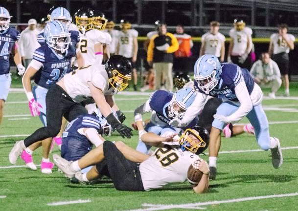 West Milford ball carrier Jeffrey Papienuk lands on the turf after being tackled by Sparta defenders in the first half. Papienuk scored three rushing touchdowns in the game.
