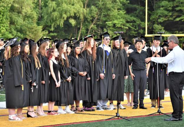 The high school choir sings the National Anthem.