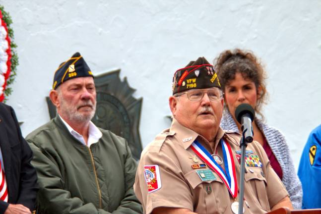 Veterans of Foreign War Commander William Johnson told the group, &quot;I am an American Veteran.&quot; Behind him to the left is American Legion Commander Bob Allwood, and to the right is Mayor Bettina Bieri.