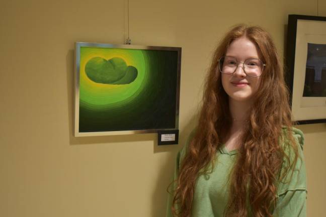 West Milford High School senior Daphne King, 17, who is also a member of the National Art Honor Society, with her imaginative work of art. Shewas among other high school students who helped mount, frame and hang the artwork at the library.