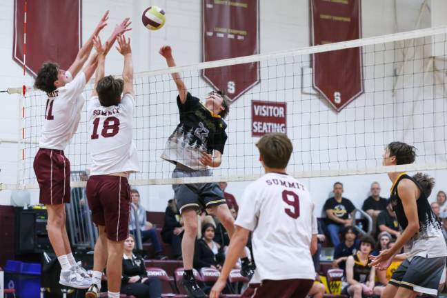 VB5 Matt Landoline of West Milford follows through on a kill attempt, while Summit’s Oliver Hogan and Tristan Guenther go up for a block attempt.