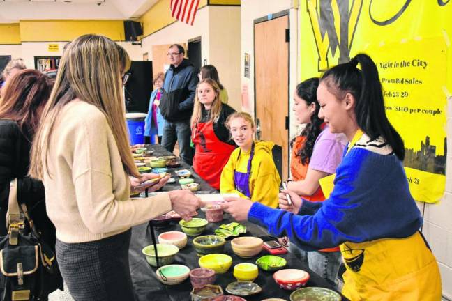 West Milford High School students serve soup in handmade ceramic bowls as part of the ‘Empty Bowls’ project to fight hunger.