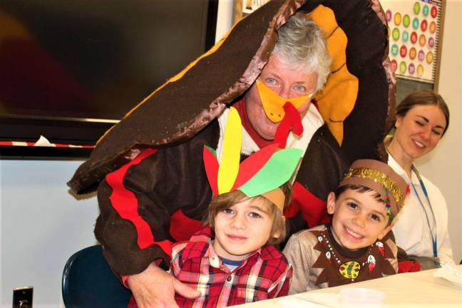 Ringwood Christian School Administrator Dr. Furrey along with two Kindergarten students during the Thanksgiving celebration Nov. 20.