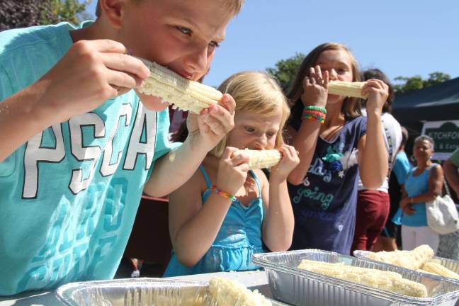 Brenden Battavio of Jefferson and Macy and Molly Sabo of Long Valley compete in a corn eating contest.