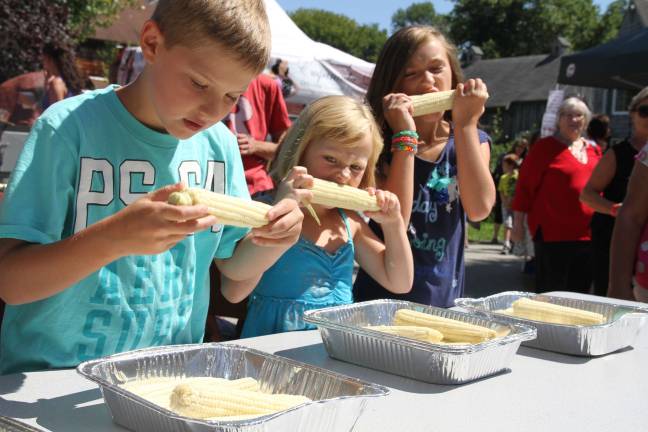Brenden Battavio of Jefferson and Macy and Molly Sabo of Long Valley compete in a corn eating contest.