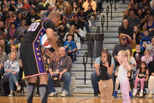 A Harlem Wizards team member shows the girls how to hold their hands.