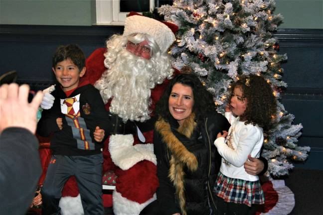 Santa Claus gets last minute instructions and lists from the children during Monday night's tree lighting.