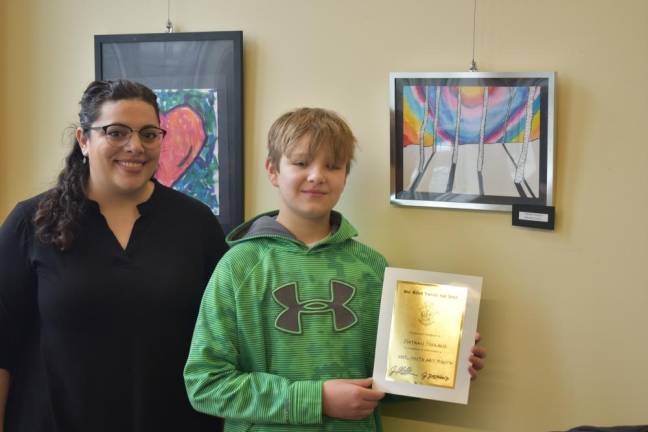 Fifth-grader Nathan Niskayuna poses in frsnt of his artwork with Jessica Ziegenbalg, who teaches art at Paradise Knoll and Apshawa elementary schools.