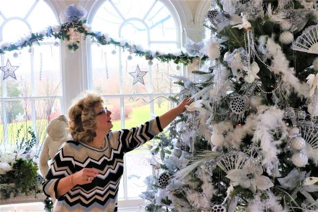 Women's Club President Tina Ree puts out items on a Christmas tree for display at Ringwood Manor.