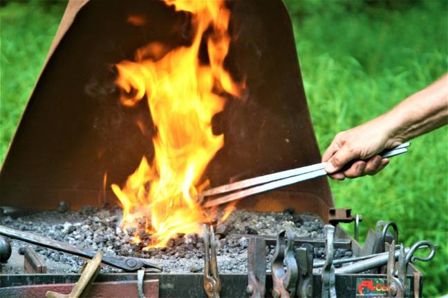 [Wyckoff Blacksmith Gaspar Lesznik conducts a field demonstration of 19th century metal work at the Long Pond Ironworks State Park in Hewitt on Saturday. Charles Kim photo]