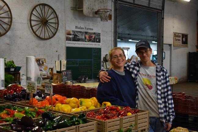 Kasha Bialas and son Thomas Focarile, 17, at their farm stand in the black dirt of New Hampton, N.Y. Seeds were delayed in the spring, and the price of plastic bags and greenhouse plastic doubled. (Photo by Becca Tucker)