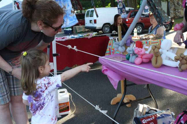 Two-year-old Claire Hazelman knows what she likes. She chose a pig for her balloon animal. Her mom, Renata Hazleman, liked that choice.