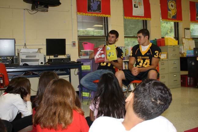 Jason Maxwell, left, reads to the kids in Janelle Peine's class at Westbrook Monday as part of the team's Punt, Pass and Read program, encouraging reading for all kids, all ages.