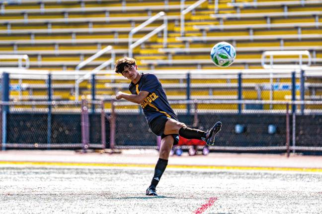 Junior Jacob Friere kicks the ball.