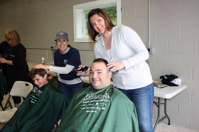 Co-chair of the St. Baldrick's event, Dave LeMay, and son Evan give it up together. Photo by Ginny Raue