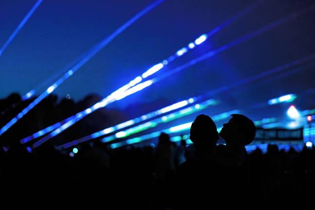 A man and boy look up at the laser show. (Photo by TJ Nolan)