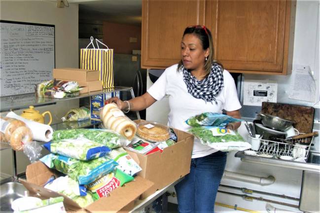 Charles Kim photo A volunteer from Strengthen Our Sisters goes through food donations at a local shelter.