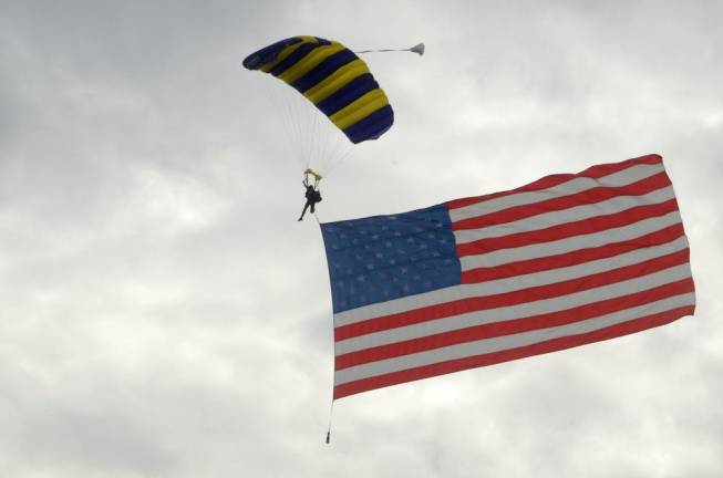 A skydiver bails out of a plane at high altitude flying the American flag during the opening ceremony at the Greenwood Lake Air Show.