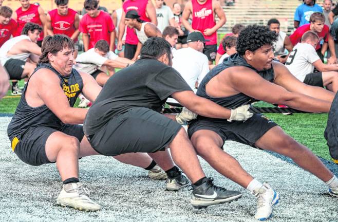 Ronnie DeGraff, J.C. Milone and Tado Kopic participate in the tug of war.