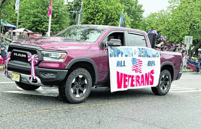 A truck drives by with a sign in suppot of veterans.