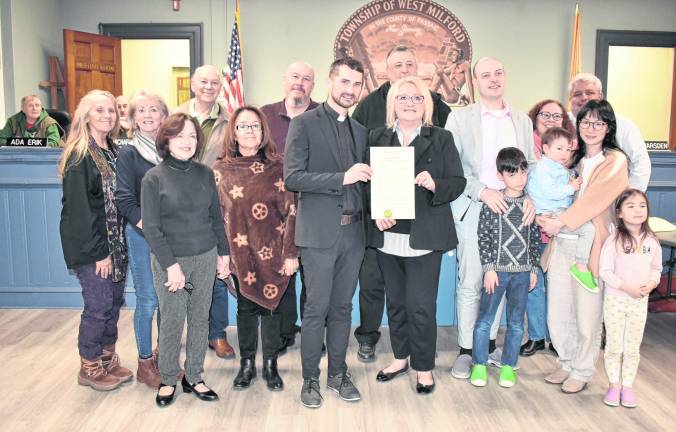 West Milford Mayor Michele Dale presents a proclamation to Father Jakub Grzybowski in honor of the parish’s 260th anniversary.