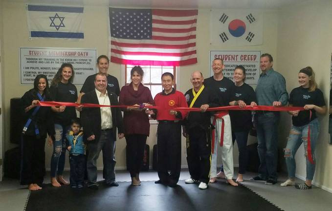 A larger group celebrated the grand opening inside the building including, from left, Alyssa Vinas, Laura DiGirolamo, Councilman Lou Signorino and his son Luciano, Jr., Master Charlie DiGirolamo, Mayor Bettina Bieri, Grand Master Won Keun Bai, James Cooke, Rich Brand, Winona Brand, Councilman Peter McGuiness and Anna Brand.