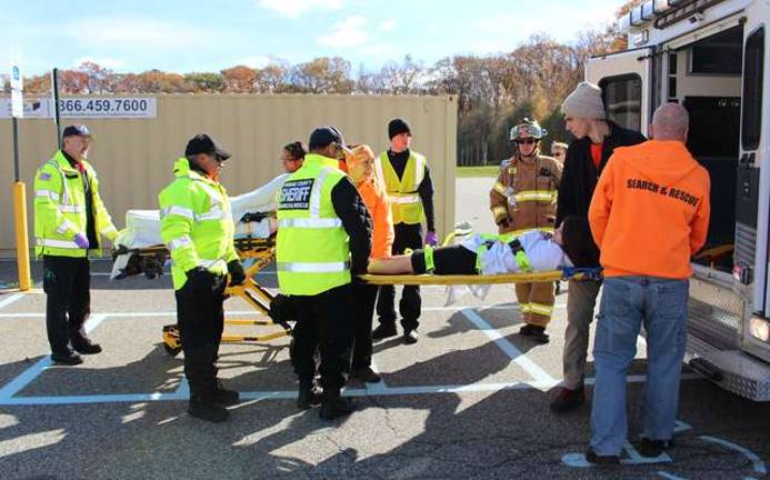 EMTs load one of the "victim" into a waiting ambulance.