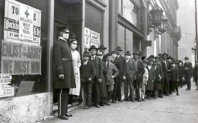People wait in line to get flu masks to avoid the spread of Spanish influenza on Montgomery Street in San Francisco in October 1918.