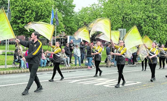 The West Milford High School Highlander Band flaggers march during the parade.