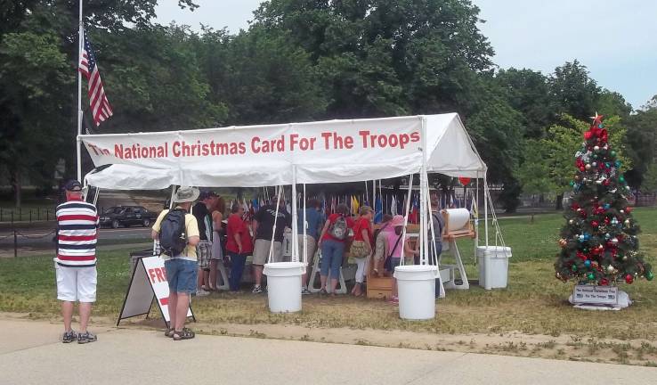 People line up to sign The National Christmas Card for the Troops, at the Trochan brothers’ tent.