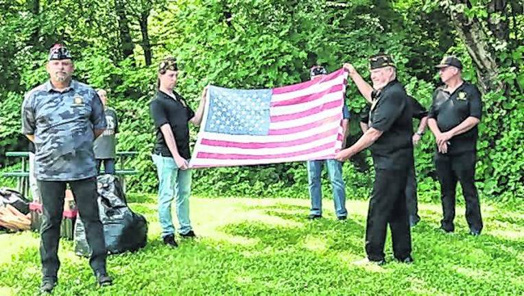The West Milford Veterans of Foreign Wars hold an American flag.