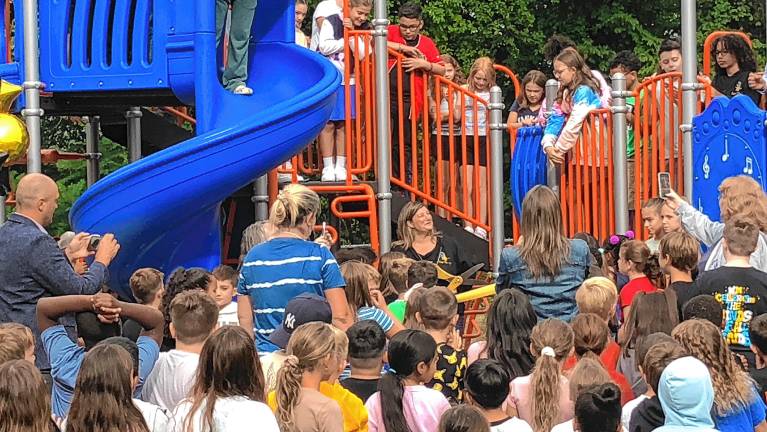 Marcia Kershaw, center, president of the Upper Greenwood Lake Elementary School PTA, prepares to cut a ribbon for the new playground equipment there Friday, Sept. 5. (Photos by Kathy Shwiff)