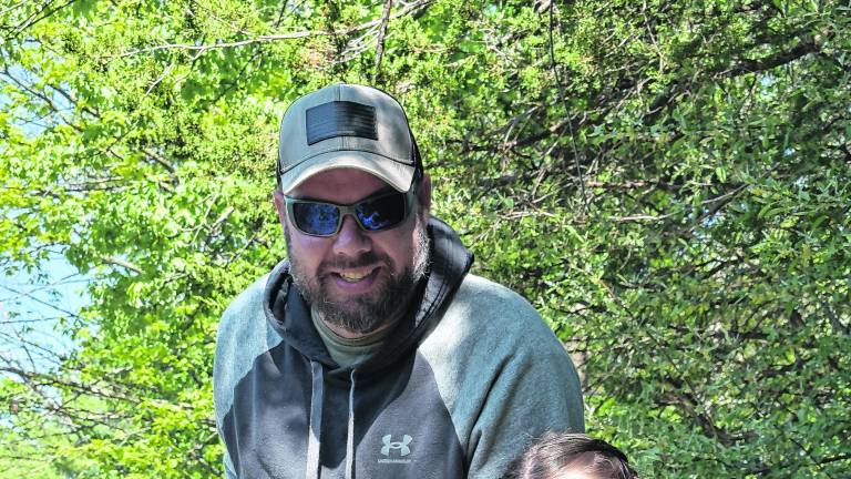 Youngster Jordyn, with dad, after catching a fish, said, “I like the grey ones best. I fish in my backyard where I catch lots of fish. And I always take the hook off myself.”