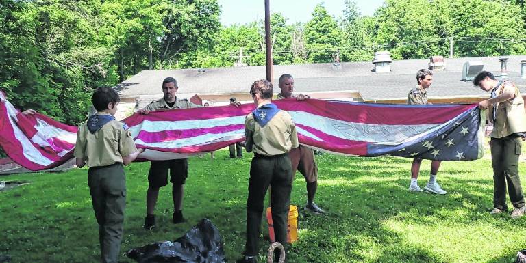Boys scouts open an American flag.