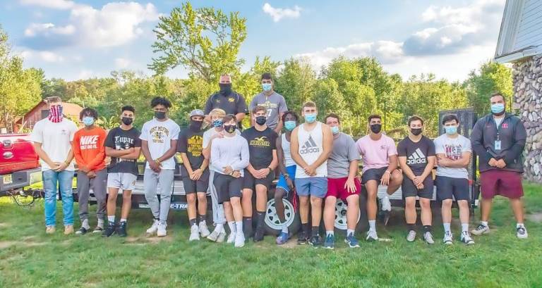 Members of the West Milford High School’s football team helped the Friends of the West Milford Township Library move all the books from the West Milford Presbyterian Church’s garages to the barn at the Wallisch Homestead for the annual book sale. Photo by Don Wright.