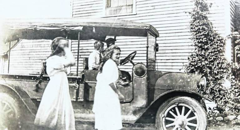 West Milford Mathews sisters, Verina and Anna, board a school bus for Butler High School in 1920 with student Fred Vreeland already on board with the driver.