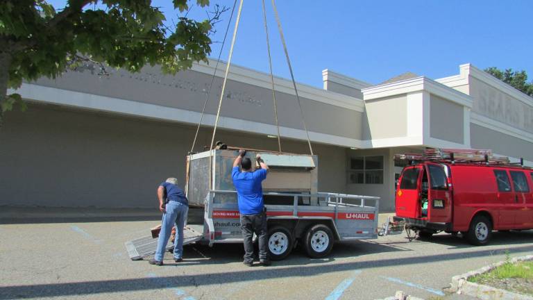 Continuing work at the Tractor Supply Store in Hewitt on Aug. 24 involved use of a crane to remove an old air conditioner through the building roof. Photo by Ann Genader