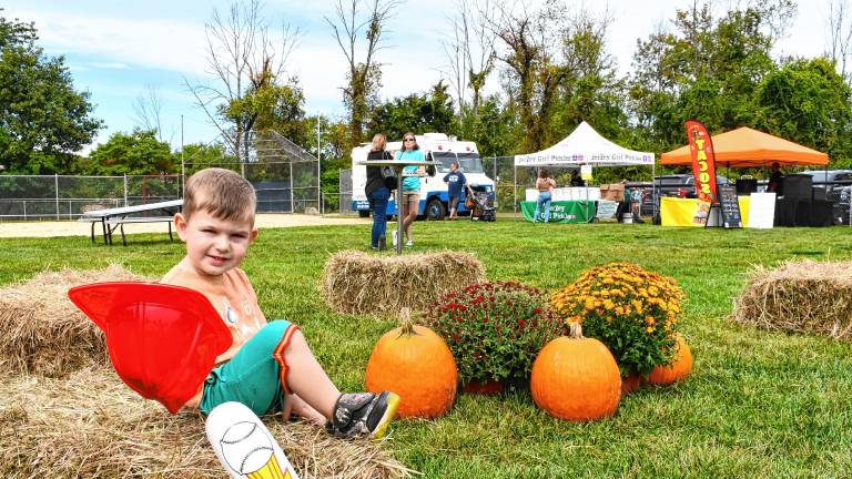 Cameron Riccardi of Stanhope plays among the pumpkins at the Stanhope Fall Festival on Saturday, Sept. 27. (Photo by Maria Kovic)