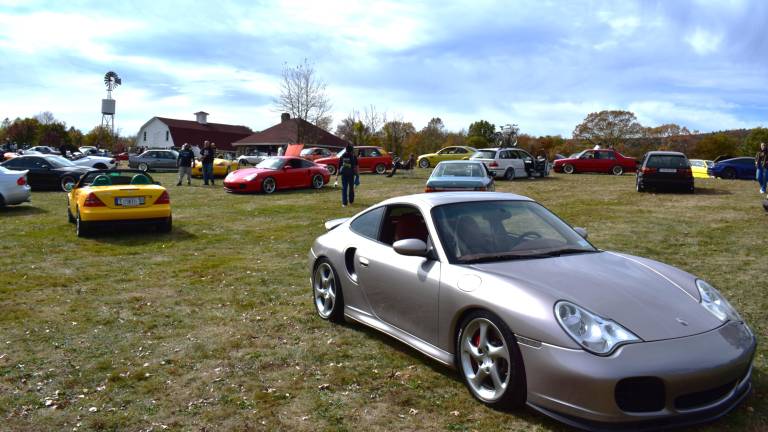 A field of clean, well-maintained custom and stock exotic super cars are shown.